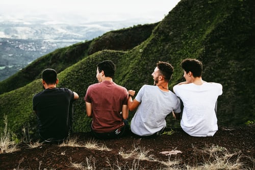 fire menn som sitter på en ås